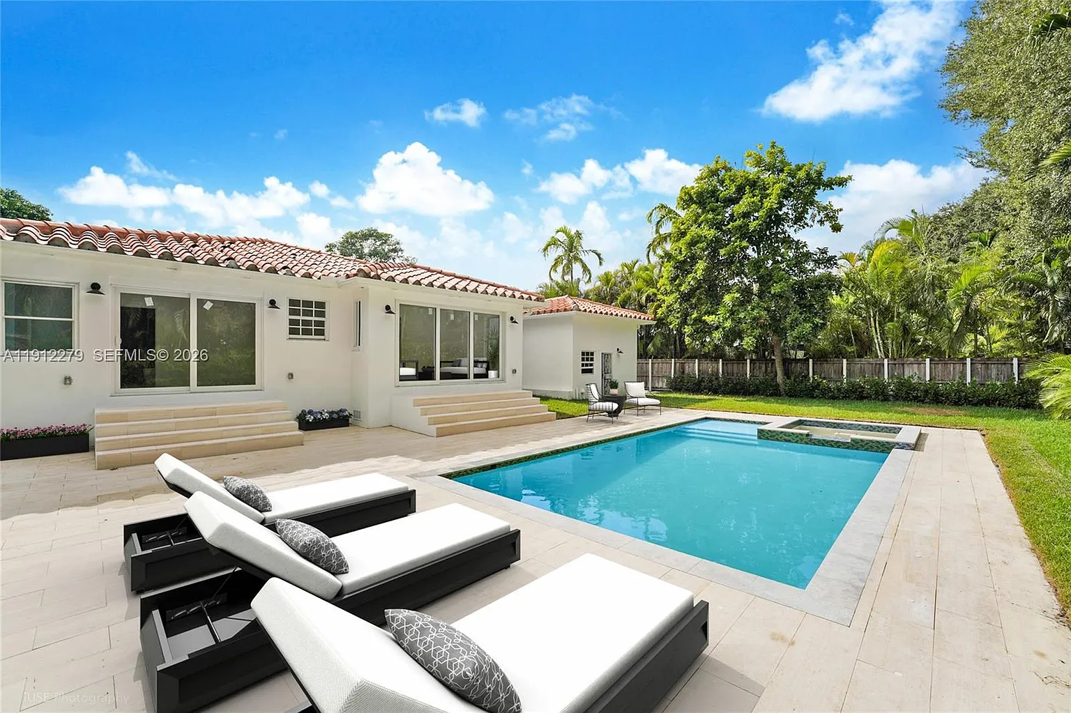 Modern pool with waterfall feature and outdoor living
